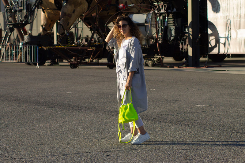 Model carrying leather bucket bag in yellow neon 